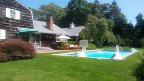 Huge backyard drowning in flowers, with a pool close to the house