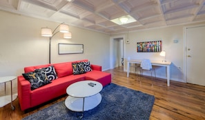 The living room has warehouse plank wood floors and a desk working space