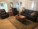 Comfortably furnished living room with leather, high ceilings and lots of light