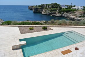 Large pool with children's safe area, seating, dive platform and waterfall