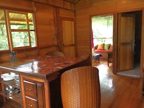 View of kitchen with comfortable hand woven seating for 4 & attached living area