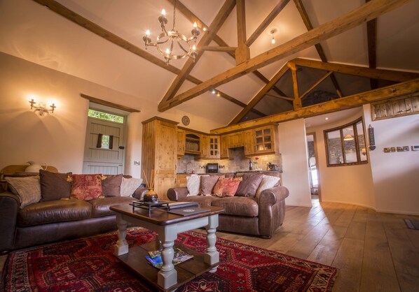 Open plan living room with beautiful oak kitchen, exposed beams and stonework 