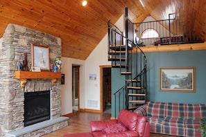 The gas fireplace and spiral staircase up to the loft area.