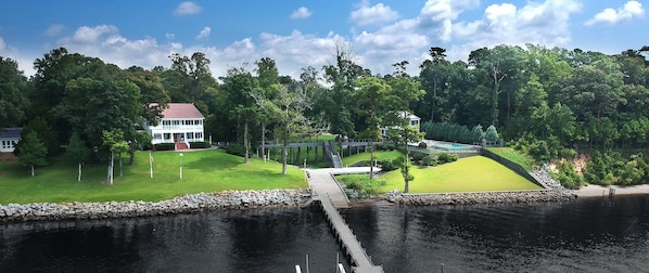 A bridge connects the pool house/deck (right) to the main house (left)