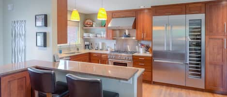 Gourmet kitchen opens to dining and living areas. 6 burner stove, warming shelf.