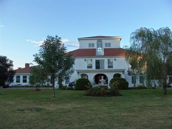 Front view showing the three story atrium, portico and fountain.