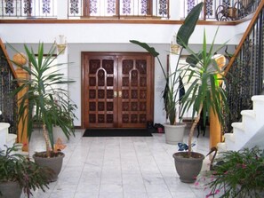 The carved wooden door front entrance,marble floor and wrought iron railings.