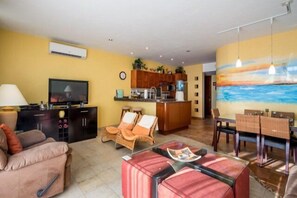 The common area has comfortable couches, chairs, and a dining room table