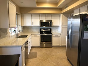 Fully stocked kitchen with granite and stainless appliances