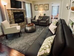 The well-appointed living space with comfy chairs, large windows, and fireplace.