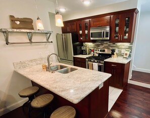 The bright, well-equipped kitchen features a gas stove and breakfast bar.