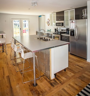 Modern IKEA kitchen with large island and coffee bar, opens to large deck