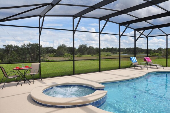 Screened patio with large pool and spa overlooking conservation area.