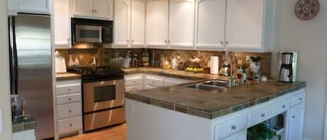 Beautiful kitchen features slate counters and backsplash, stainless appliance