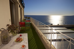 Large sunny terrace with dining area and sofa and sun beds