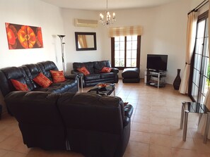 Spacious lounge area with aircon, internet TV, and direct access to patio