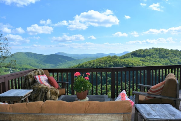 The outdoor living room has an expansive view of the surrounding mountains.