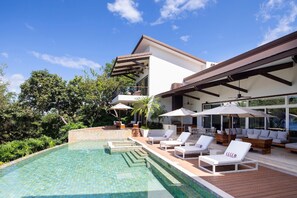 Stunning swimming pool, complete with luxurious lounge chairs and shaded umbrellas