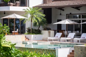 Stunning poolside with comfortable chairs, shaded by elegant umbrellas.