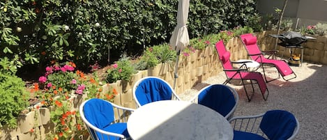 Jardin privé avec espace repas, bains de soleil, parasol, barbecue Weber au gaz