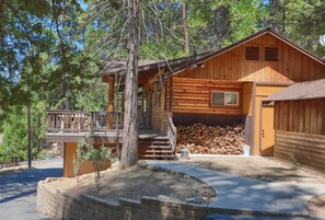 Side view of cabin with lots of firewood