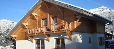 Le chalet avec balcon et grandes baies vitrées sur façade sud