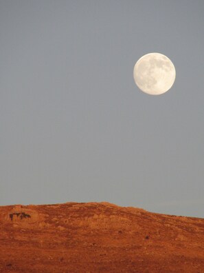 August moon rising over the mountains