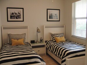 Second bedroom with two twin beds and television (off screen)