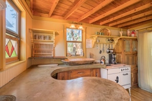 Very unique kitchen with wood ceilings, concrete countertops, antique wood sink