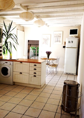 The fully equipped kitchen with table and chairs.