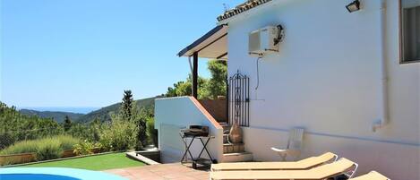 Side of the villa with sun loungers by the private pool with stunning sea views