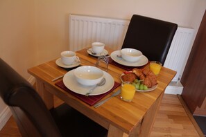 Solid oak dining table and high back leather chairs for comfortable dining