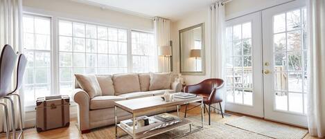 Bright, airy living room with double doors that open onto front deck.