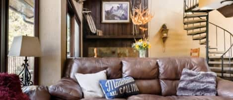 Floor to ceiling windows in the living room with comfy leather couches