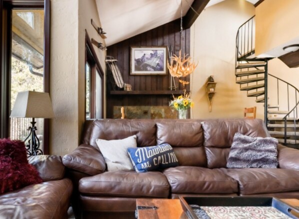 Floor to ceiling windows in the living room with comfy leather couches