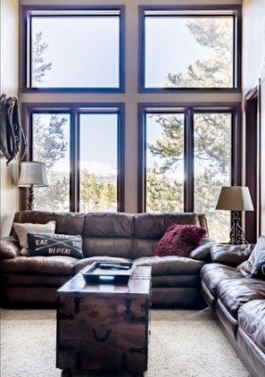 Floor to ceiling windows in the living room overlook Peak 9.