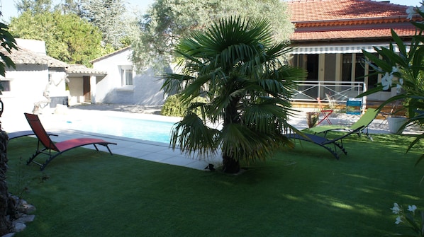 Entrée de la maison avec sa piscine et ses transats