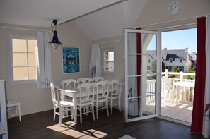 salle à manger et partie du balcon avec table et chaises 