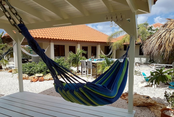 Opposite your apartment is a gazebo with 2 hammocks and chairs to relax
