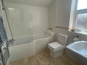 Bathroom with L shaped bath and shower over