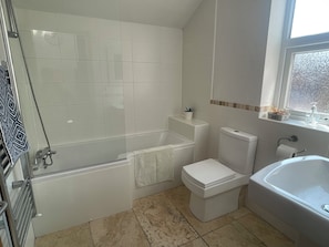 Bathroom with L shaped bath and shower over