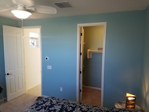 Spacious room with walk in closet and ceiling fan.