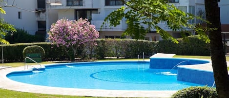 The main community swimming pool surrounded by beautiful gardens