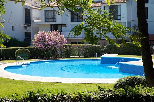 The main community swimming pool surrounded by beautiful gardens