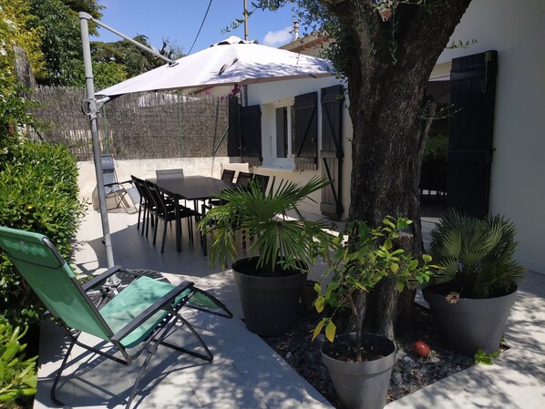 Terrasse avec mobilier de jardin et barbecue

