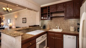 Kitchen is fully stocked with dishes glass ware, oven stove top and refrigerator