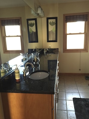 Updated bathroom with granite countertops, heated floors and triple shower heads