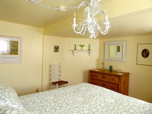 Shabby chic bedroom with antique chandelier and dresser