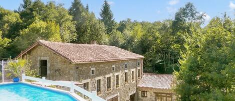 Swimming Pool with view of gites below and the woods/playing fields beyond.