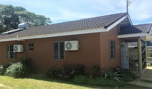 Window screens, split a/c units, lush green plants throughout the landscape